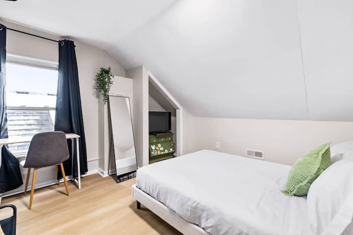 ¡Explora nuestro hermoso dormitorio con un elegante espejo, un espacio de trabajo dedicado, una acogedora cama con almohadas suaves y un televisor para relajarte!