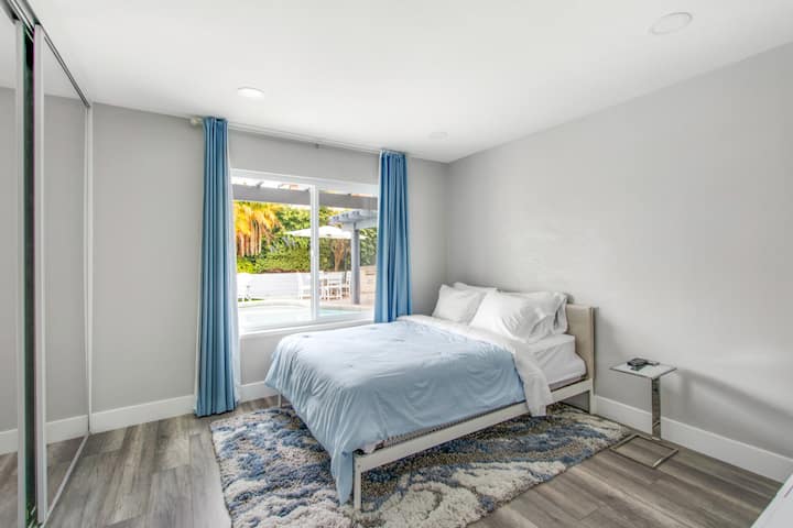 Spálňa 2: Veľká posteľ, skriňa, komoda, 48-palcová inteligentná televízia s rozhraním HDMI, mobilný stôl a výhľad z okna na bazén.