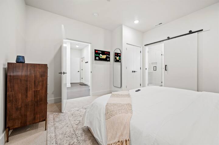 تتميز غرفة النوم الرئيسية بسرير فاخر بمقاس كينج وحمام داخلي وتلفزيون ذكي بشاشة كبيرة ومساحة تخزين واسعة.