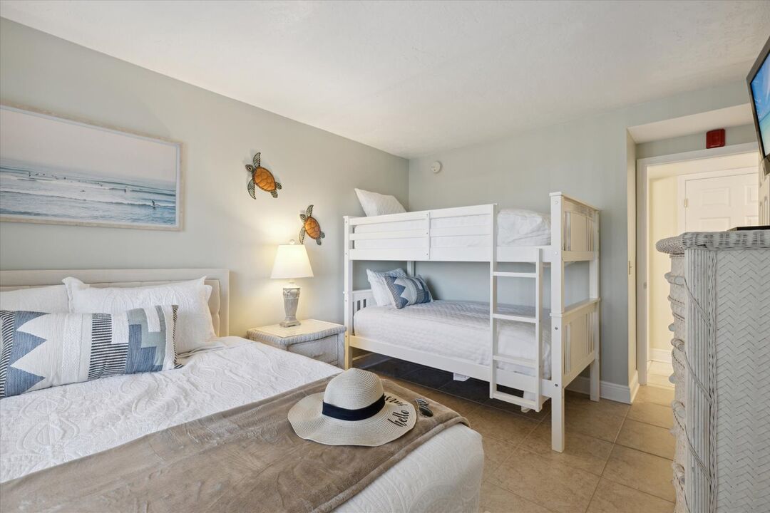 Dormitorio familiar con una cama queen y literas.