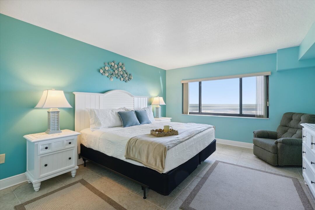 Cómodo dormitorio principal con una cama tamaño king y vistas al océano.