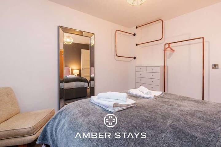 Una sala de estar elegante y cómoda, bañada por luz natural y con asientos acogedores para relajarse o socializar