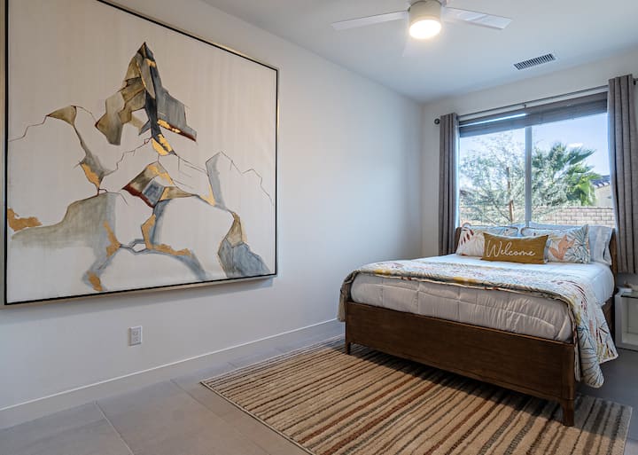 明亮迷人的卧室，配有舒适的床、山地风格的艺术品和窗外景观。