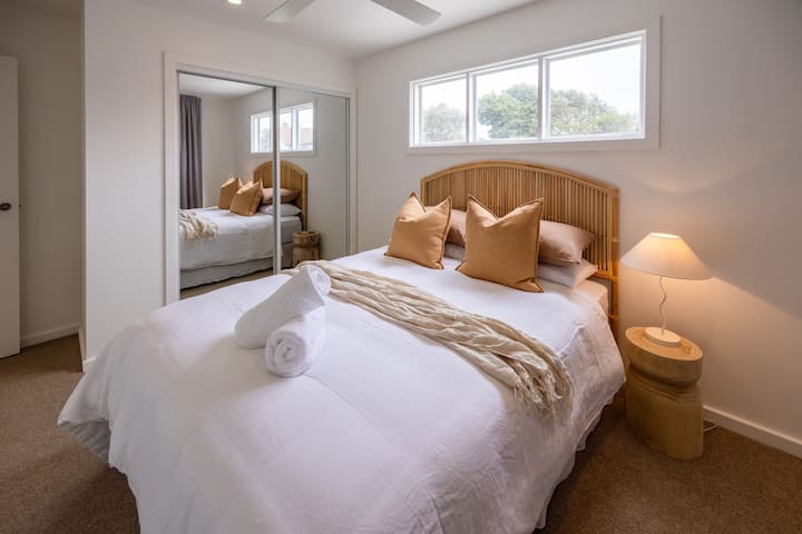Bedroom 2 with queen bed, wardrobe and ceiling fan.