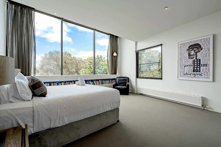 Amplio dormitorio principal con techo elevado y acristalamiento para una escapada de lujo