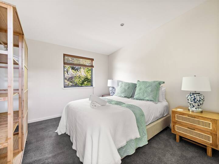 עוד חדר שינה קינג מרווח עם עיצוב חם והרבה אור טבעי שיוצר מקום מפלט שליו