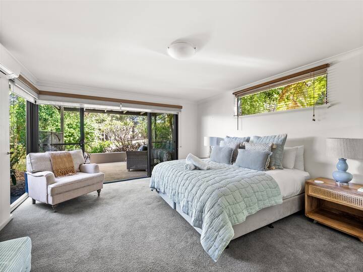 חדר שינה שקט לאורחים עם ריהוט רך עם מיטת קינג סייז ונופים מרגיעים של הצמחייה שמסביב