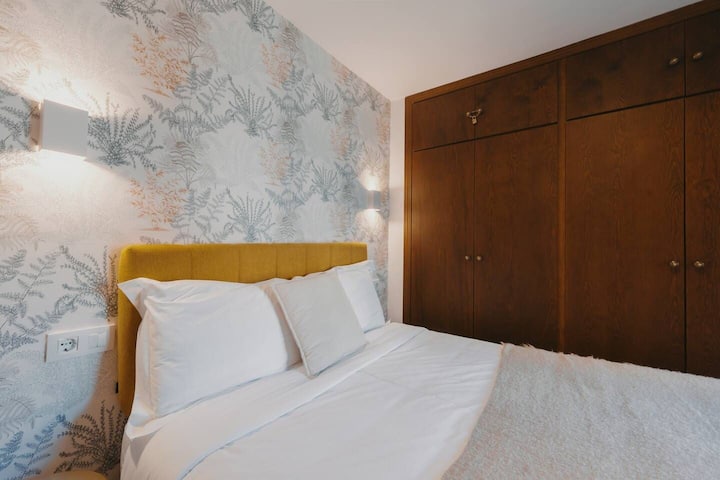 Dormitorio con cortinas opacas, almohadas y mantas adicionales.