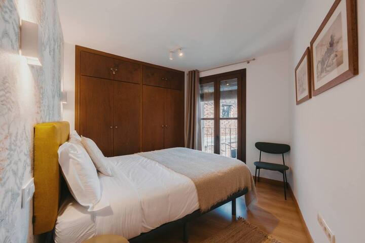 Dormitorio con armario de madera: perchas y espacio para guardar la ropa.