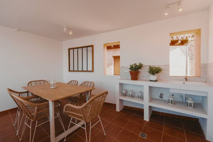 Zona de comedor con mesa para 6 y encimera auxiliar.