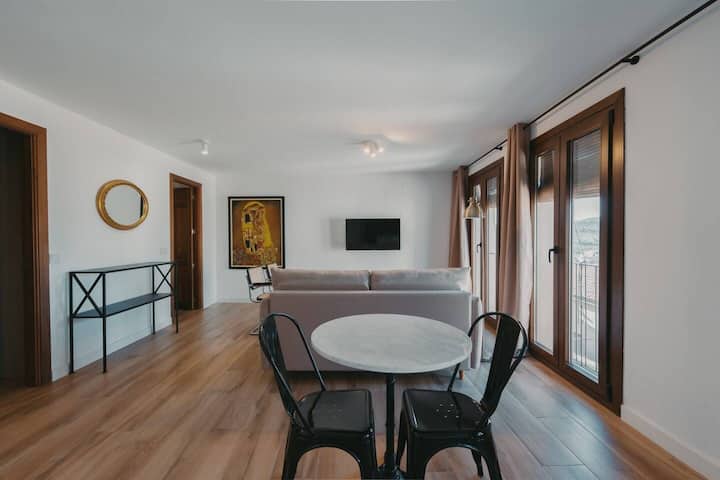 Salón comedor con mesa para 2 y balcones al casco histórico de Toledo.