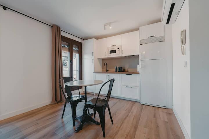 Comedor junto a la cocina: mesa para 2 y aire acondicionado.
