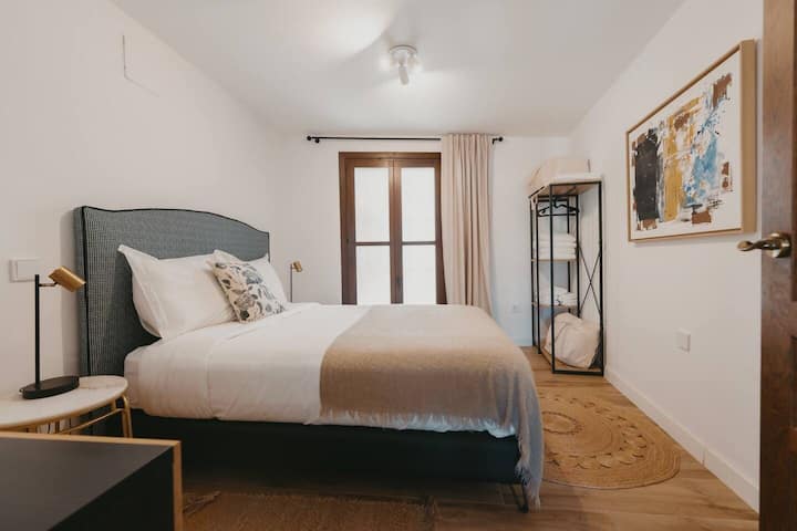 Dormitorio con perchero abierto y espacio para guardar la ropa.