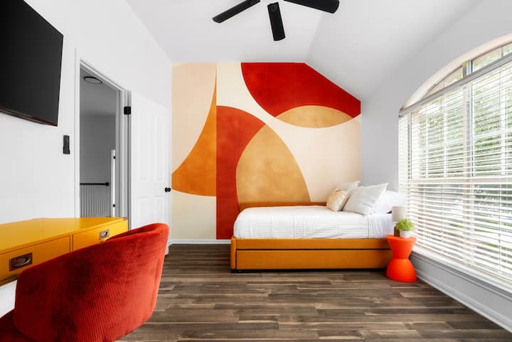 Luminoso y moderno, este elegante dormitorio cuenta con una decoración artística audaz, un acogedor sofá cama y un espacio de trabajo dedicado, ¡perfecto para la comodidad y la creatividad!