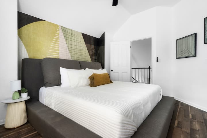 Relájate en este moderno y espacioso dormitorio, con una lujosa cama tamaño king, cálidos tonos terrosos y un ambiente sereno para la noche de sueño perfecto.