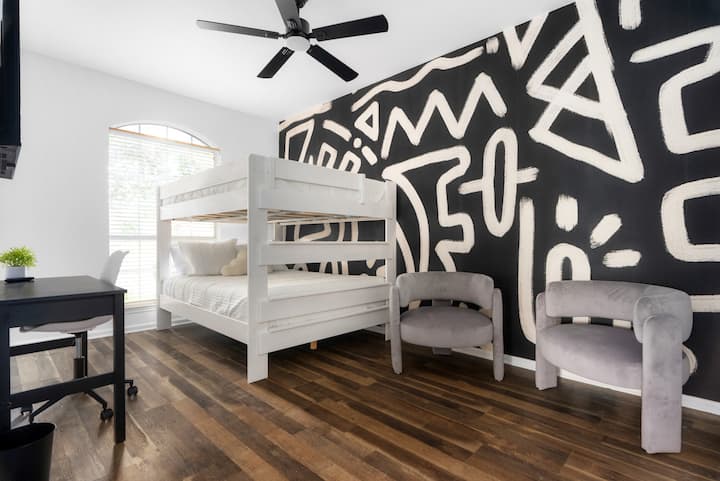 Elegante y divertido, esta habitación con literas cuenta con arte de pared atrevido, camas acogedoras y un espacio de trabajo funcional, ¡perfecto para familias o grupos!