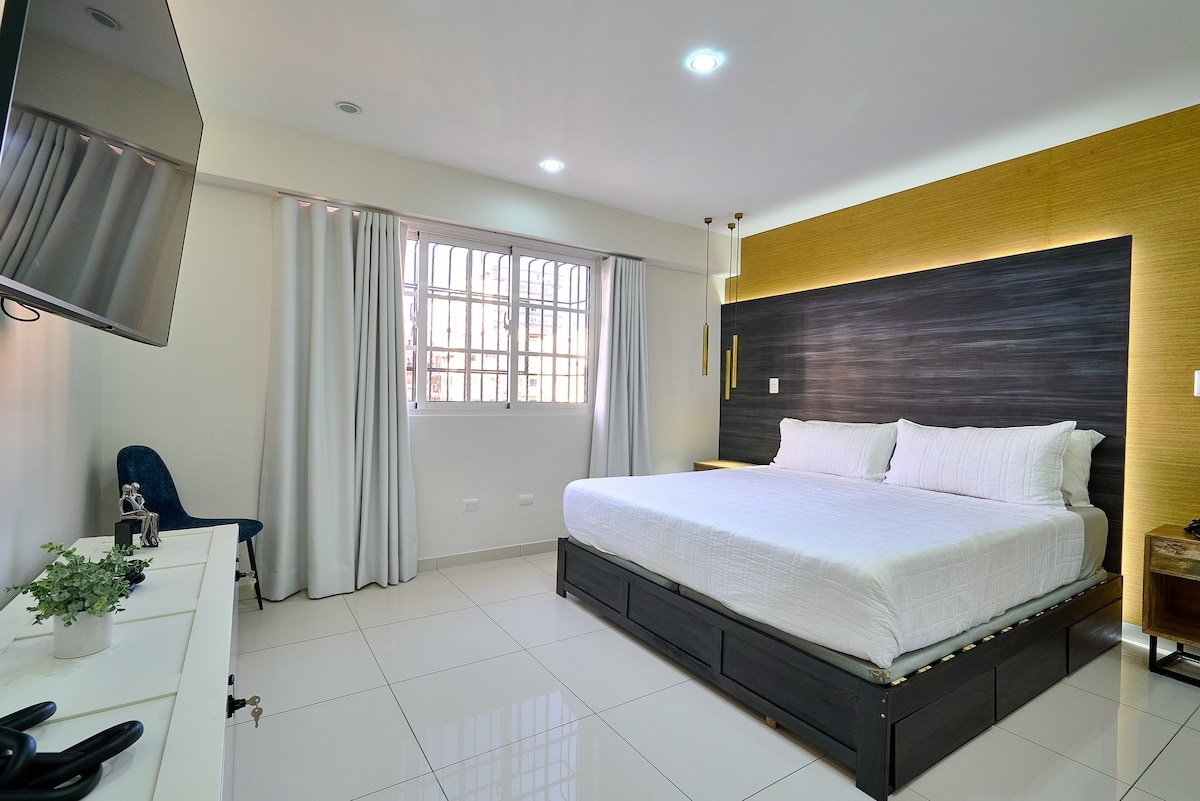Una habitación elegante y tranquila con una cama tamaño king, baño privado, TV y aire acondicionado, perfecta para parejas o viajeros solitarios que buscan comodidad y privacidad.