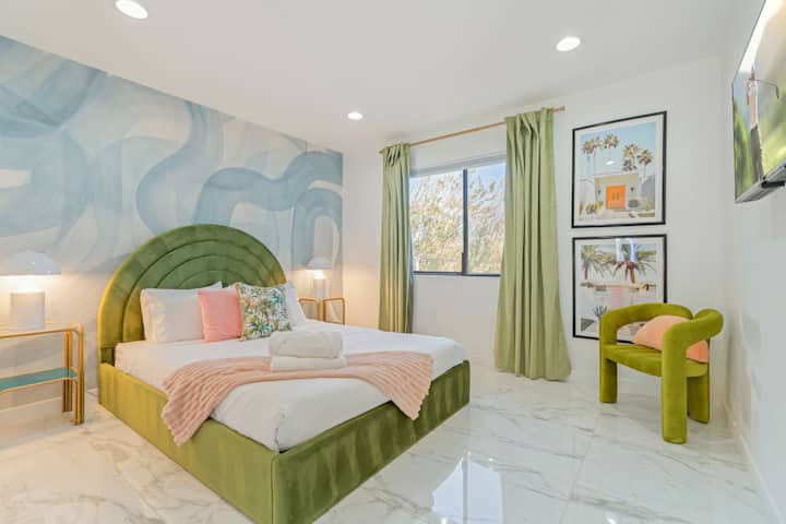 Dormitorio alegre con mural colorido, ropa de cama acogedora y luz natural que entra.