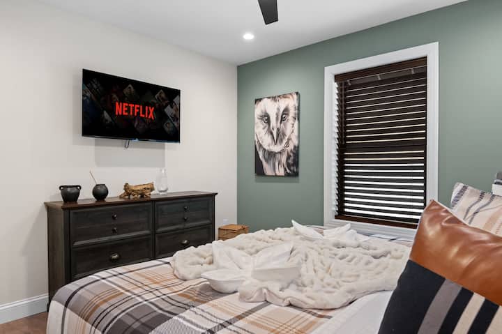 Las paredes verdes suaves, obras de arte con búho y una cama acogedora crean un refugio tranquilo, con un televisor a mano para tus programas favoritos.