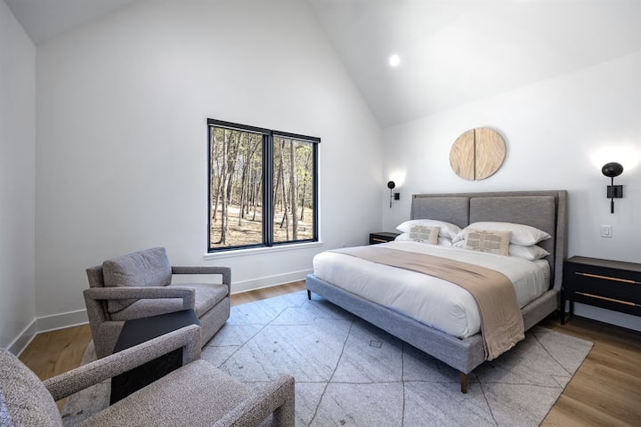 Esta suíte king no andar de cima apresenta linhas limpas e vistas relaxantes para a floresta — ideal para noites tranquilas e manhãs rejuvenescedoras.