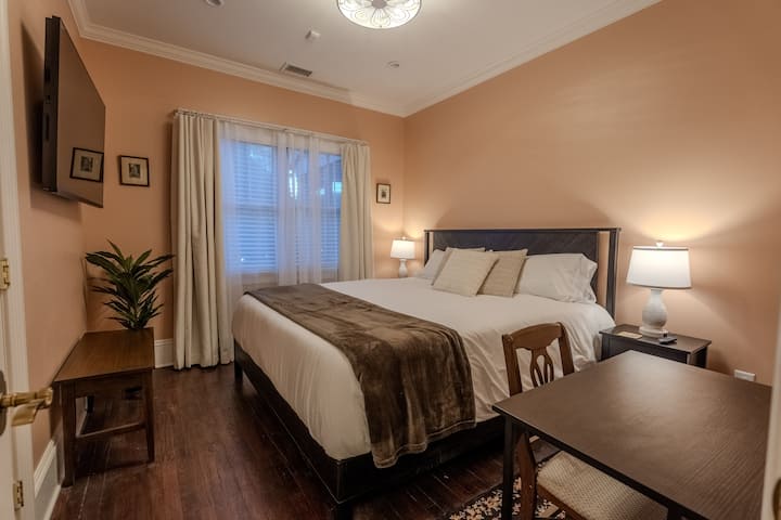 El dormitorio Oaks #3 con cama tamaño king, área de escritorio, ventilador de techo y baño privado con bañera y ducha al otro lado del pasillo