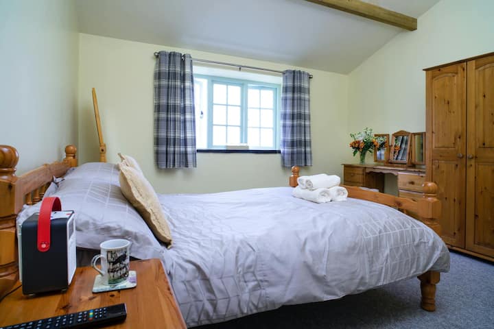 Chumba cha kulala mara mbili kilicho na kabati la nguo, meza ya kuvaa na dirisha