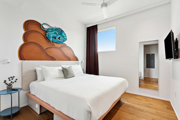 Bedroom 4: king bed, downstairs, with a private en-suite bath. Art: Crawfish by Zac Maras, spray paint on cut plywood.