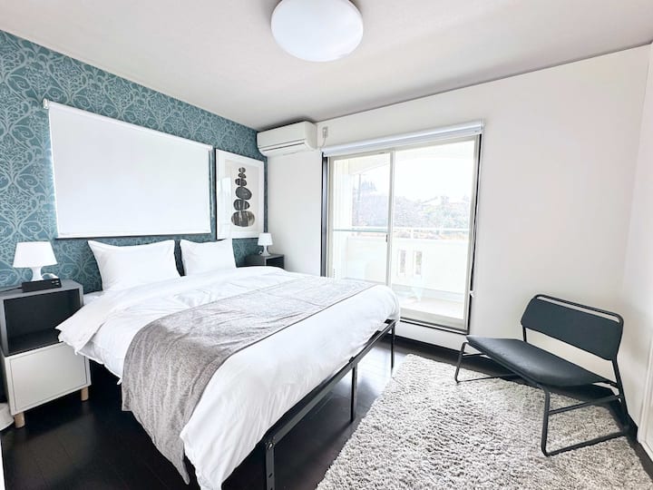 ห้องนอน 1 ที่ชั้น 2 เตียงควีนไซส์พร้อมเก้าอี้เลานจ์ 