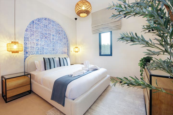 Relaxe em um quarto calmo organizado com uma cama confortável, superfícies de cabeceira e um layout equilibrado que convida você a descansar. Iluminação suave e janelas amplas suportam noites tranquilas e manhãs relaxadas durante toda a sua estadia.