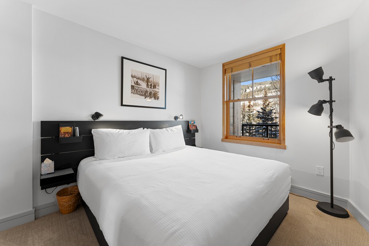 Slaapkamer met een kingsize bed en een gemonteerde tv. 