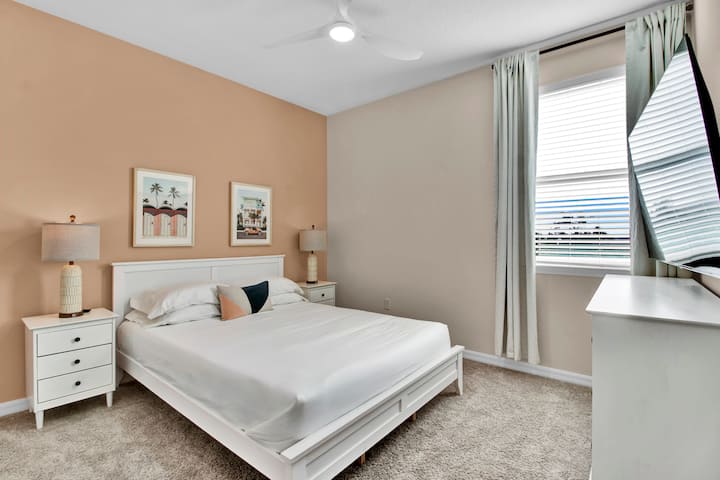 Bedroom 2 features a queen bed, TV, and shared bathroom.