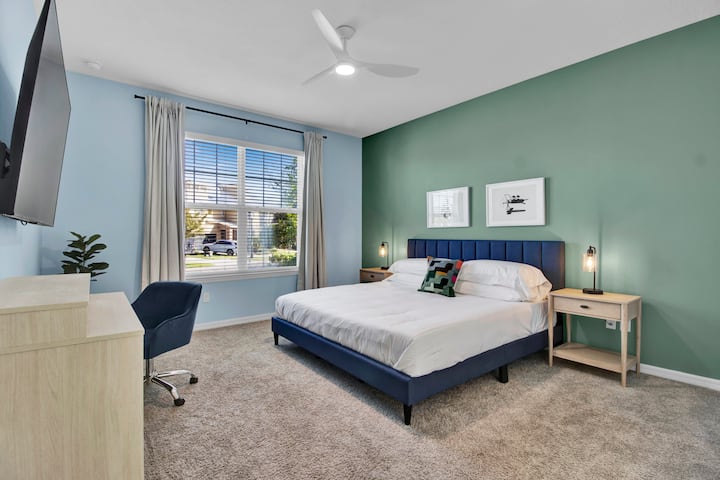 The primary bedroom features a king bed, laptop-friendly table, TV, and an ensuite bathroom.