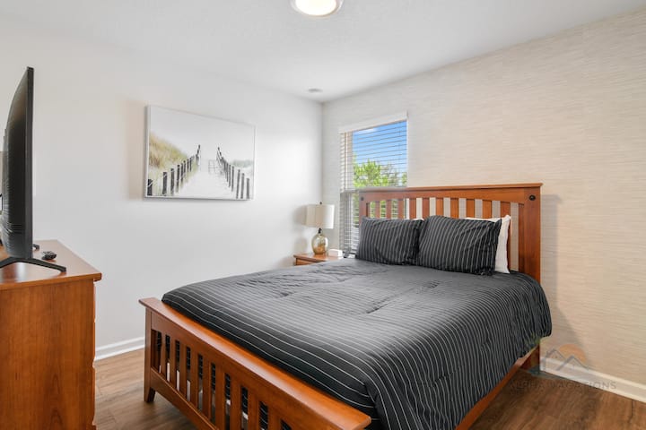 חדר שינה נעים עם מיטת קווין סייז, אור טבעי ועיצוב אופנתי.