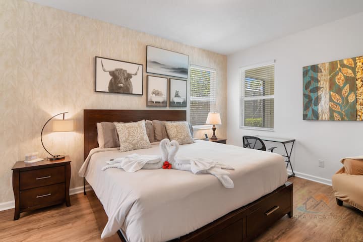 חדר שינה מודגש עם מיטה נוחה ופינת עבודה/שולחן.