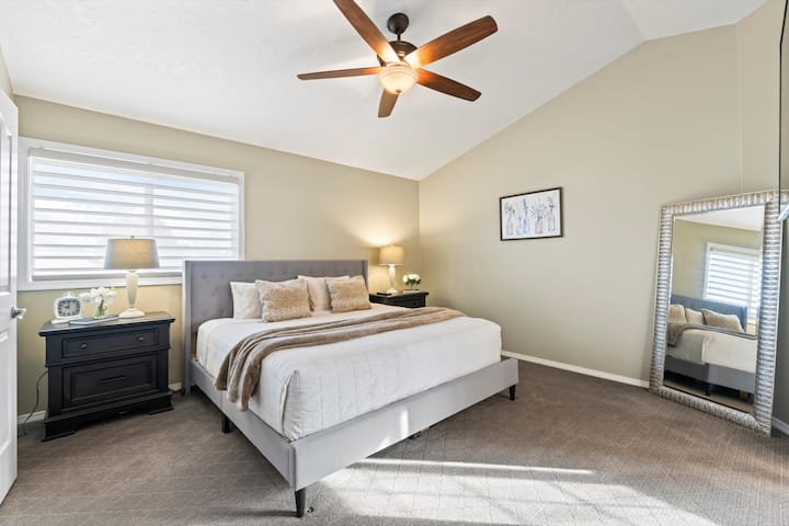 Relájate en el espacioso dormitorio principal, con una cómoda cama tamaño king, techos abovedados y ventilador de techo para mayor comodidad. Un espejo de cuerpo entero agrega un toque de elegancia y el baño privado ofrece privacidad y conveniencia.