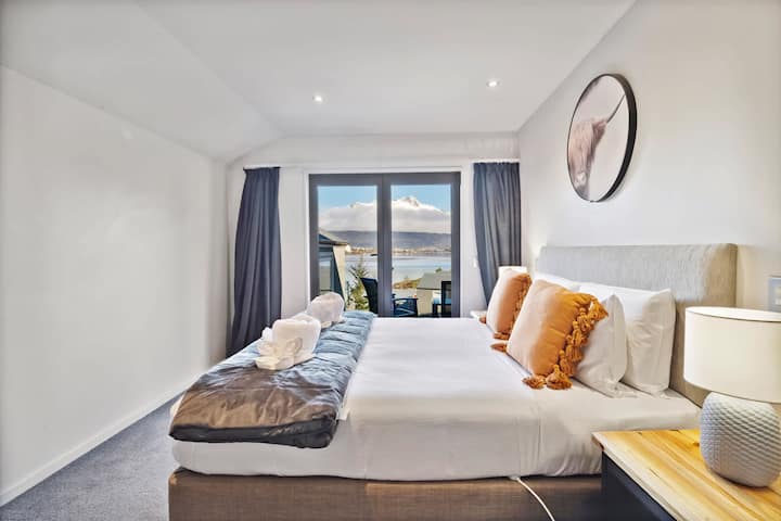 Despiértate con vistas al lago y a la montaña desde tu acogedor refugio con cama tamaño king.