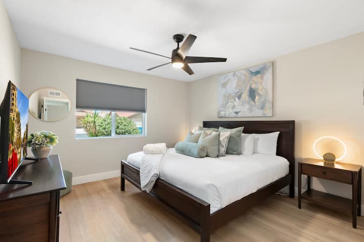 Svetlá a útulná spálňa s veľkým oknom, modernou výzdobou a televízorom s plochou obrazovkou pre väčšie pohodlie.