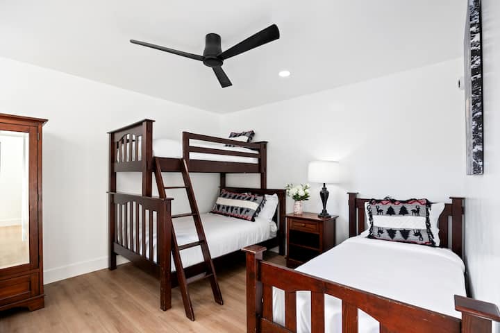 - Chambre avec lit superposé et lit jumeau pour les séjours en groupe  
- Aménagement confortable avec des meubles en bois et un éclairage d'ambiance chaleureux  
- Espace idéal pour les enfants, les amis ou un confort de sommeil supplémentaire