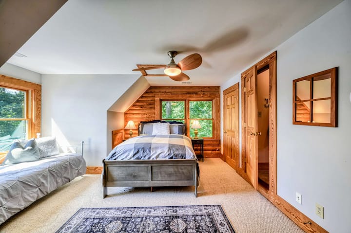 Un dormitorio luminoso y espacioso cuenta con una cómoda cama tamaño queen, un sofá cama con pintorescas vistas al lago, detalles rústicos y baño privado para mayor comodidad.