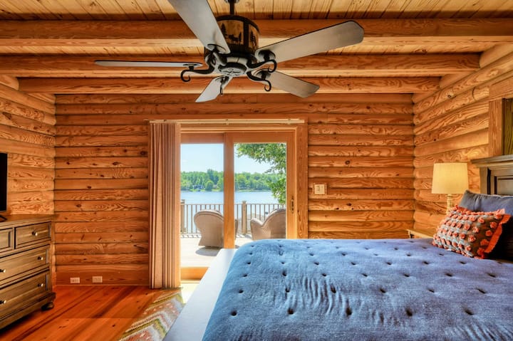 Un acogedor dormitorio con una cama tamaño king se abre a una terraza privada que ofrece impresionantes vistas al lago e incluye un baño en suite.