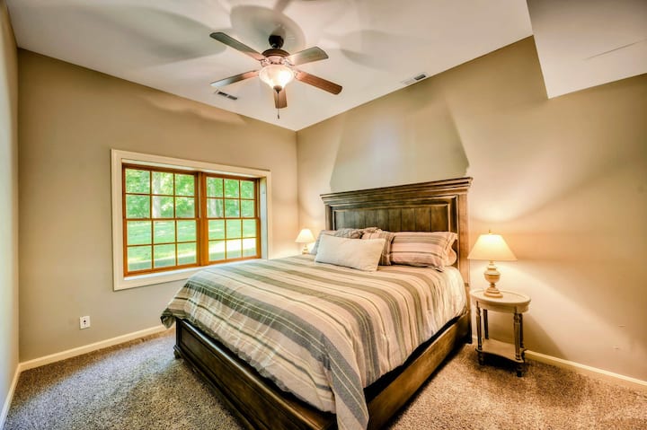 Un dormitorio tranquilo cuenta con una lujosa cama king, elegantes muebles de madera e iluminación suave, creando un ambiente acogedor y acogedor.