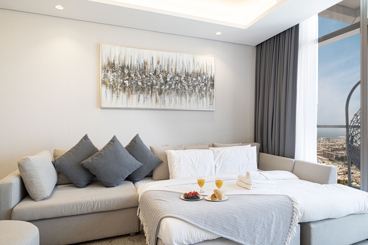 De woonkamer is ontworpen voor comfort en ontspanning, met een gezellige bank, een stijlvolle salontafel en een smart-tv, allemaal met naadloze toegang tot je eigen balkon!