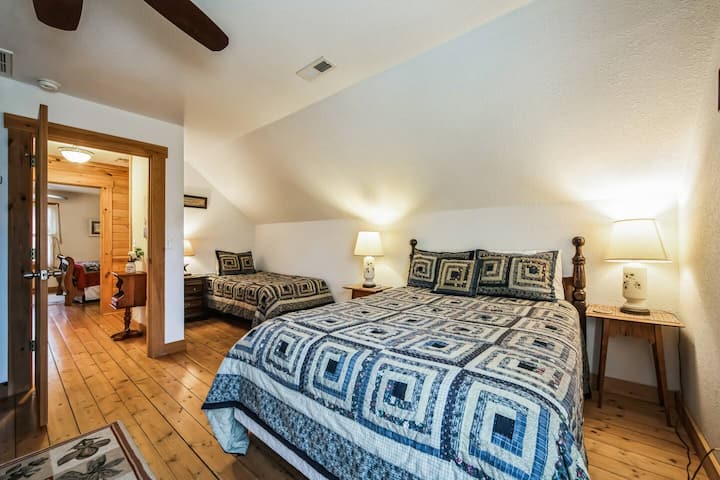 Chambre à l'étage avec des détails en bois chaleureux et beaucoup de lumière naturelle.