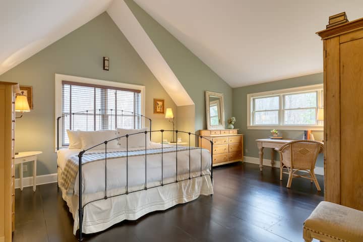 Primary bedroom features a king bed, desk, and ensuite bathroom.