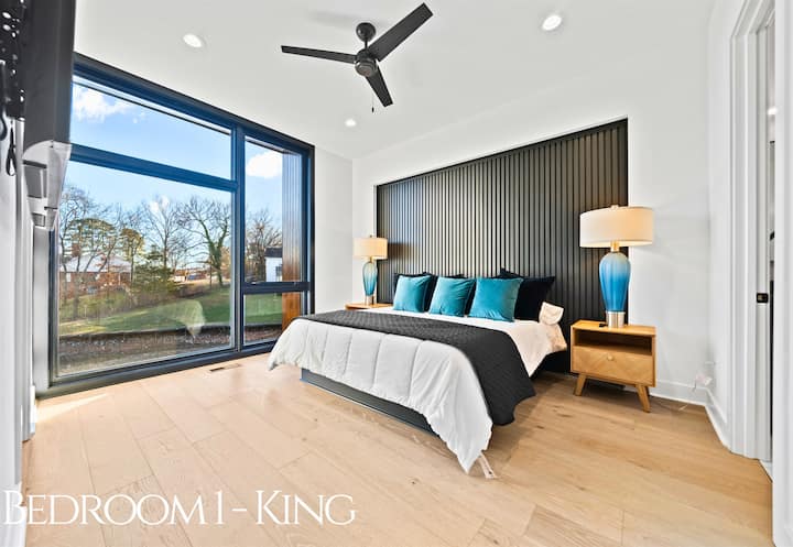 Cette chambre king size sereine dispose d'une literie moelleuse, de baies vitrées et d'une palette de couleurs sophistiquée pour une détente ultime.