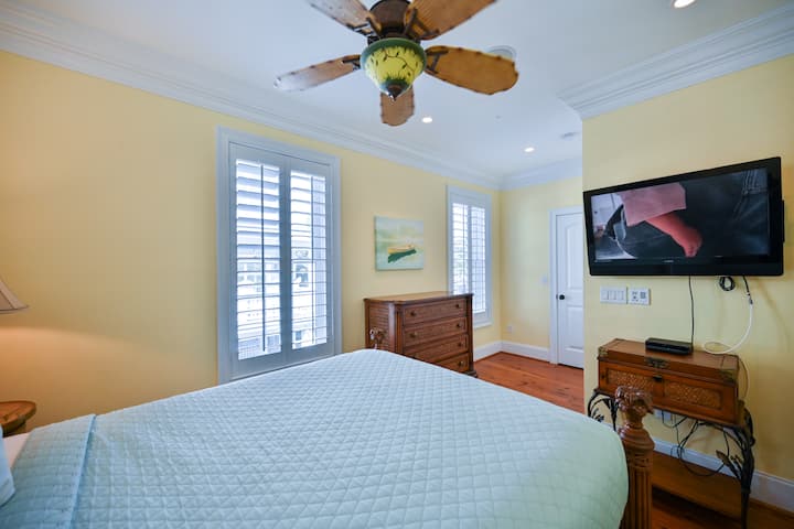 Chumba cha pili cha kulala chenye kitanda cha starehe, feni ya dari na runinga ya skrini bapa.