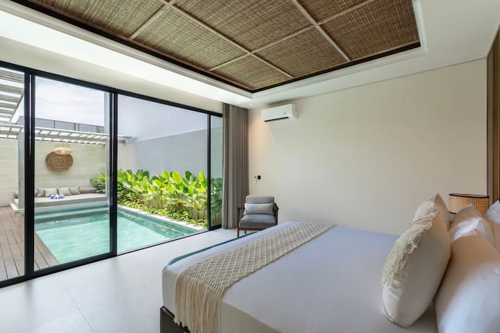 Chumba cha kulala chenye ufikiaji wa bwawa, milango ya glasi kutoka sakafuni hadi darini na mwangaza wa joto.