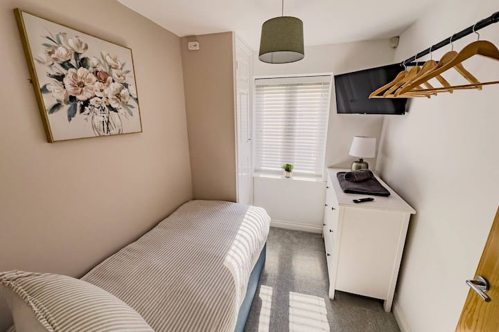 Dhomë gjumi teke me shërbime transmetimi, hapësirë për ruajtje dhe varje