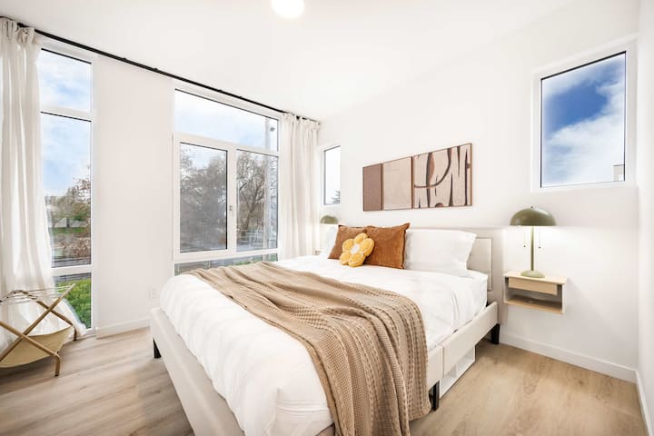 Relaxe no quarto aconchegante cheio de luz natural de grandes janelas que emolduram belas vistas ao ar livre. A cama confortável está vestida com lençóis brancos, mantas quentes e travesseiros decorativos, tornando-o o lugar perfeito para recarregar as energias depois de um da