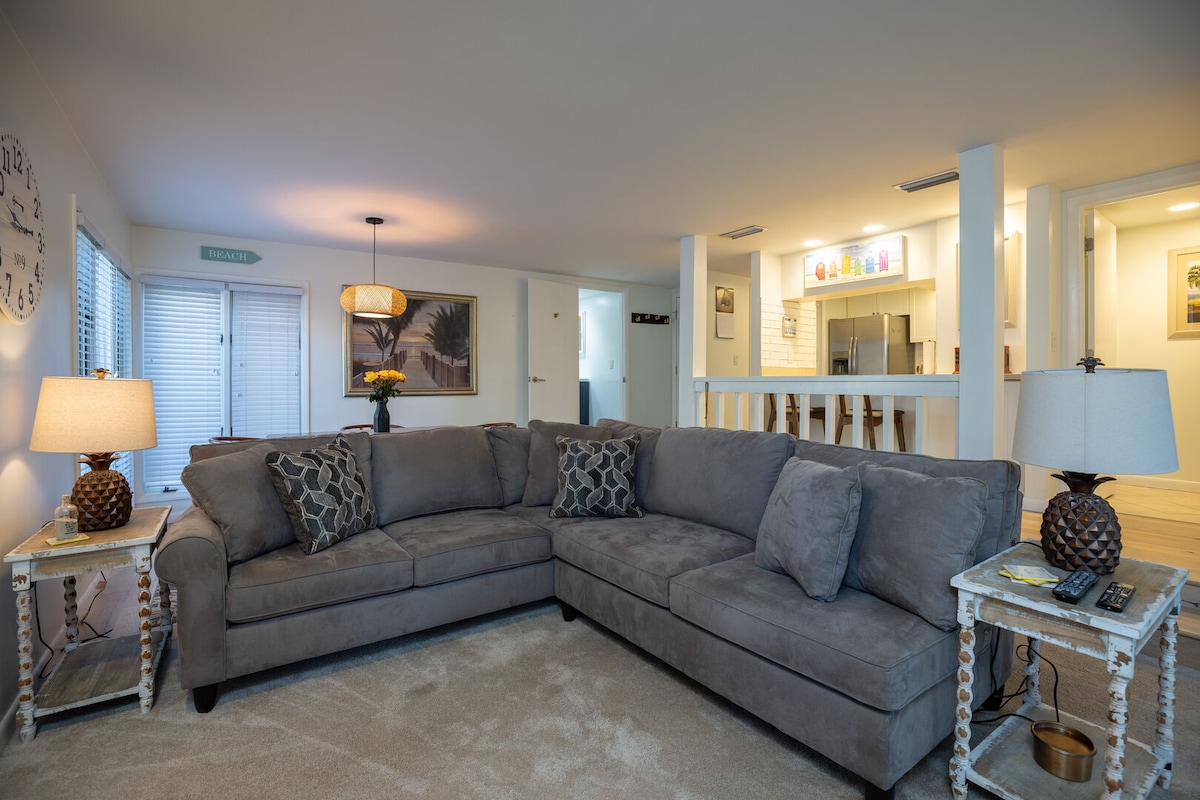 Este luminoso y abierto espacio de estar y comedor está diseñado para una vida costera fácil.